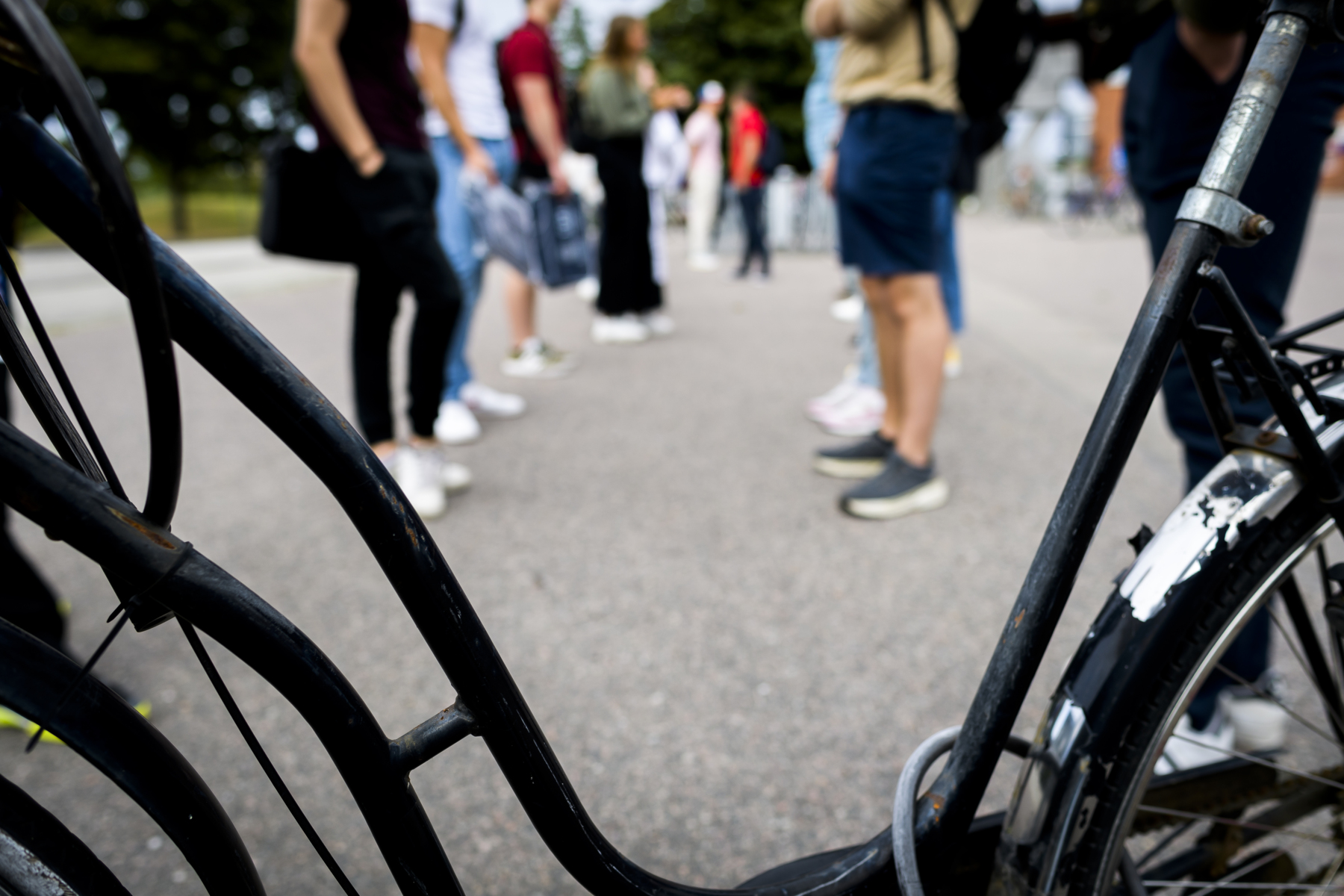 Studenters somriga ben bakom en svart damcykel. Foto taget framför Kårhuset på LTH-campus i Lund.
