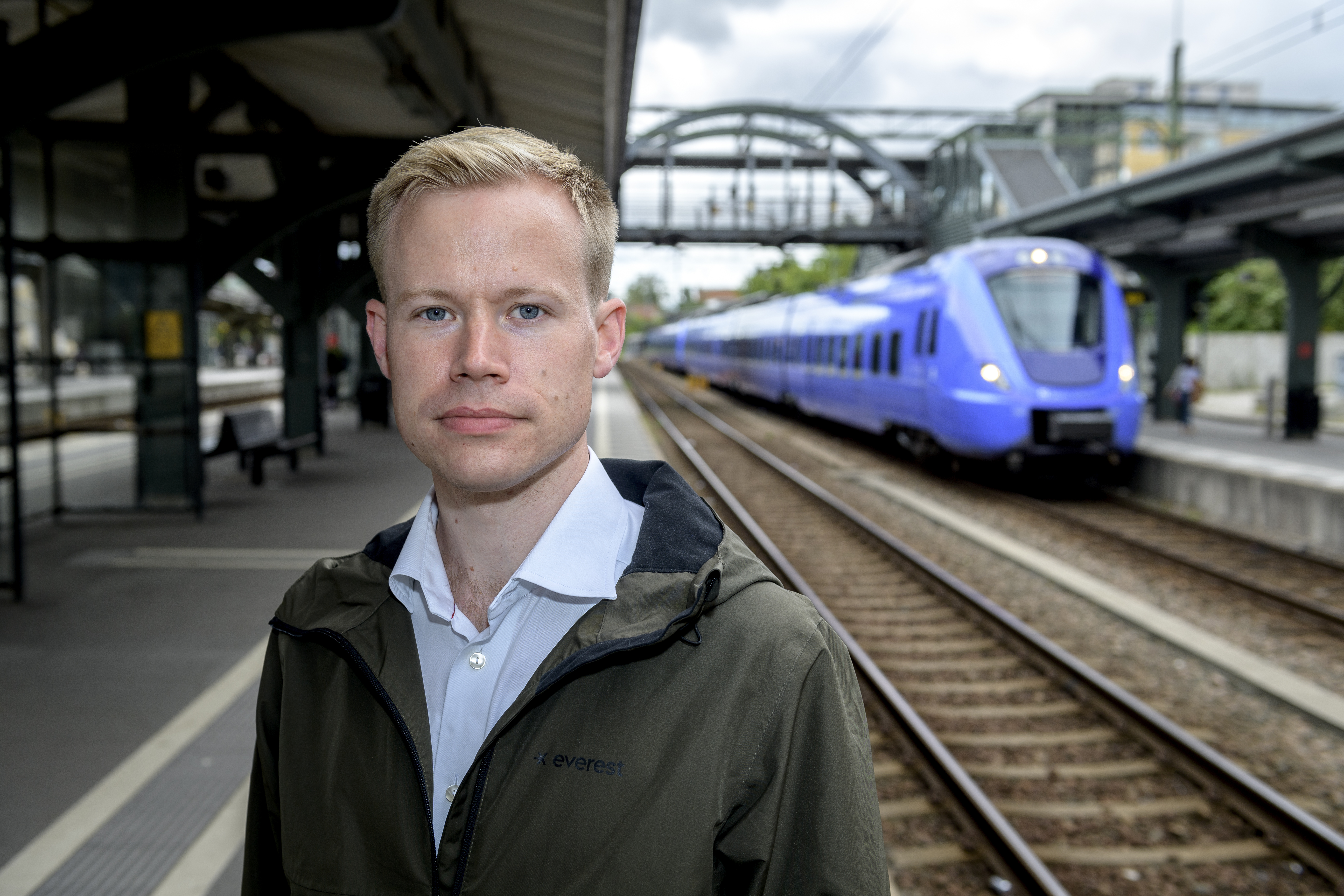 Carl-William Palmqvist with a purple train in the back ground.. Photo.