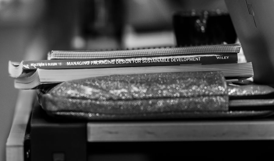 Pencil box that glitters, on top of some books. Photo.