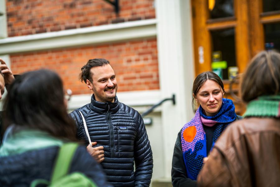 Students chatting outside a building. Photo.