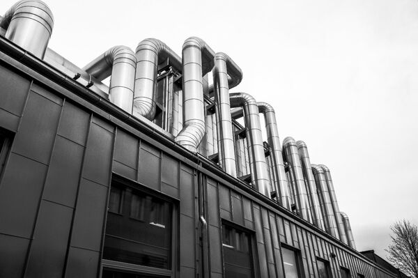 Building with aluminium tubes on roof. Photo.