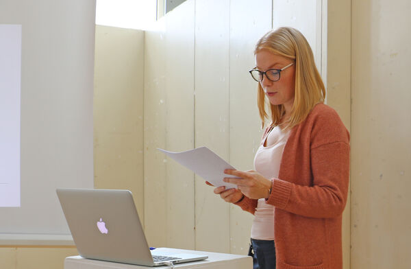 Emma Ingvarsson föreläser i A-huset med manus i hand. Foto.