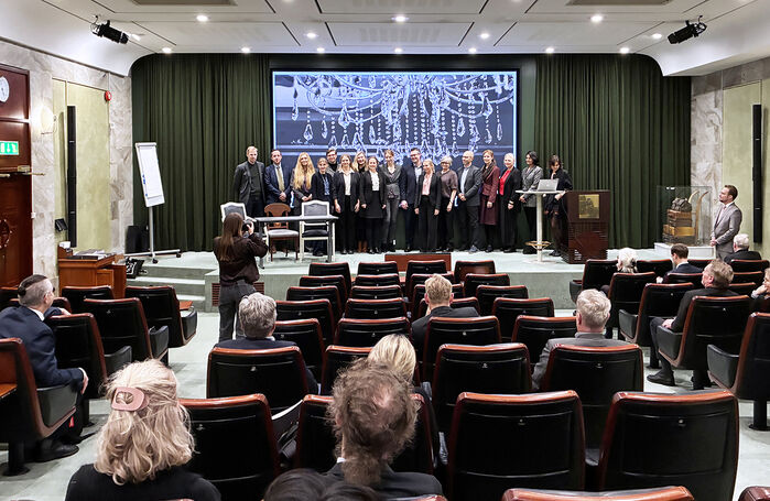 Ett tjugotal människor på en scen. Foto.