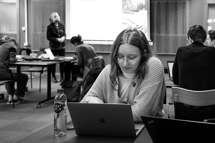 Student sitter framför laptop på en föreläsning. Foto.