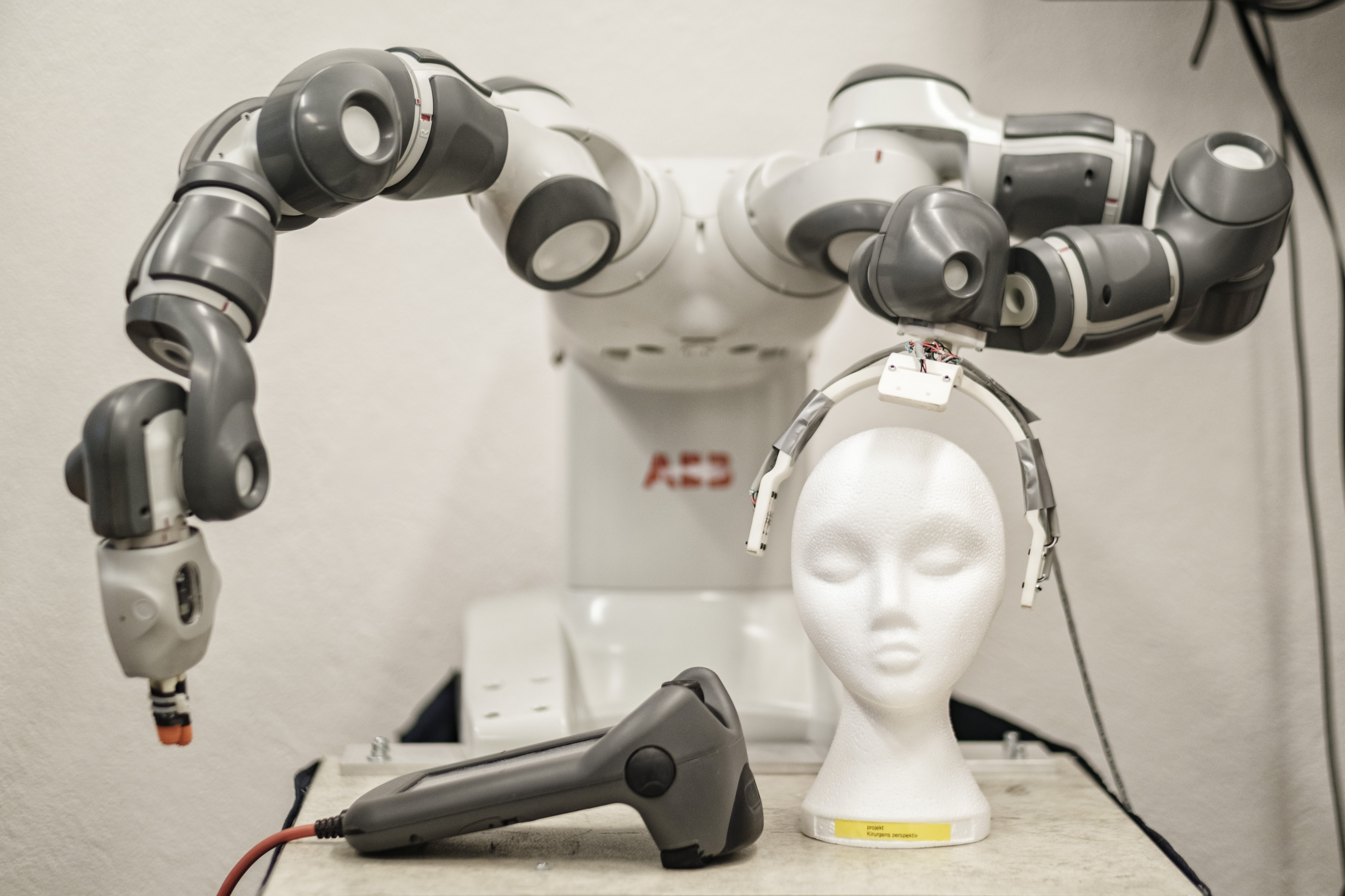 Robot arms behind a white humanlike head in the Robot lab at LTH