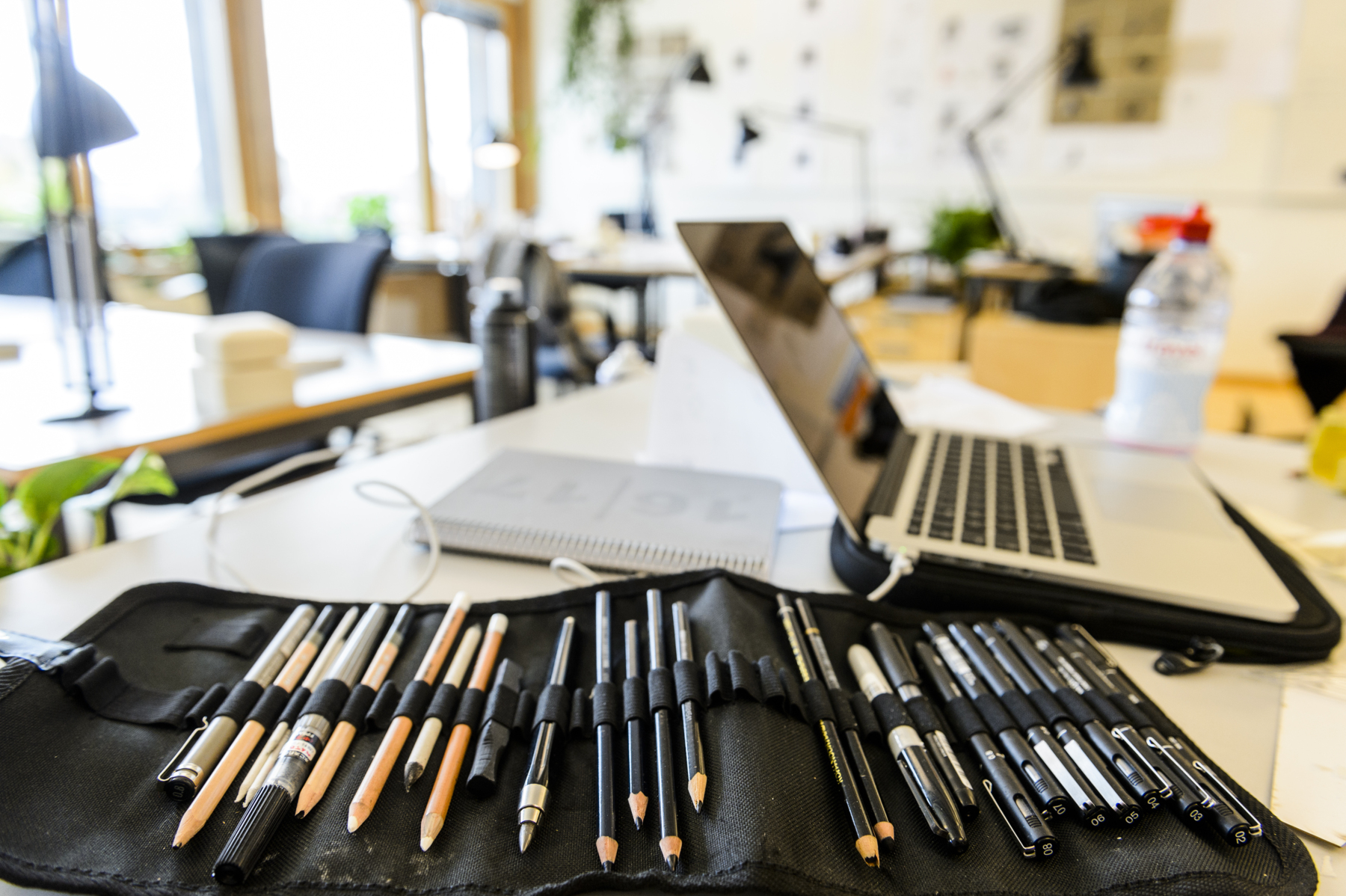 Artist pens and a computer belonging to an industrial design student. Photo.