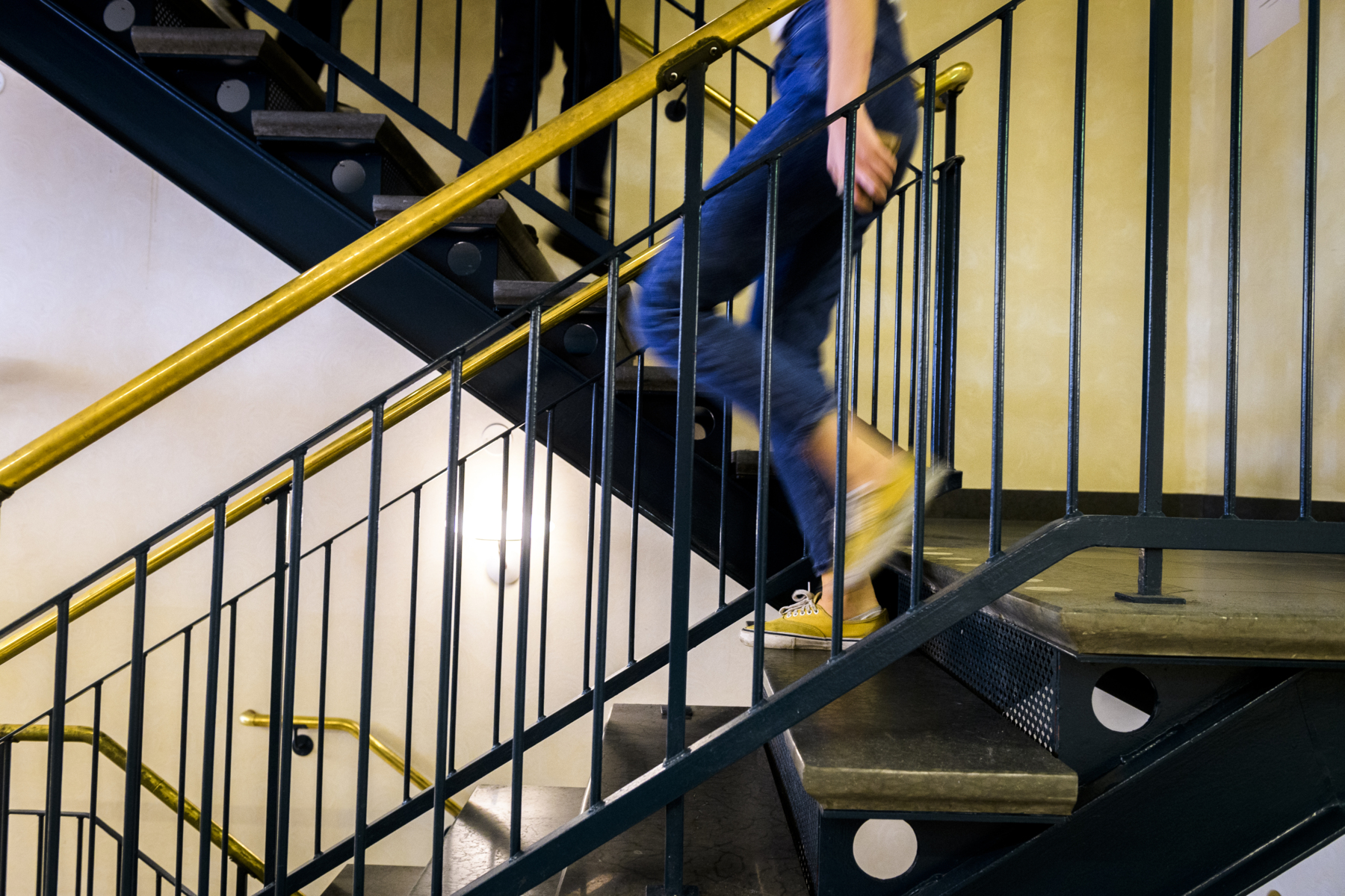 A student walking down stairs. Photo.