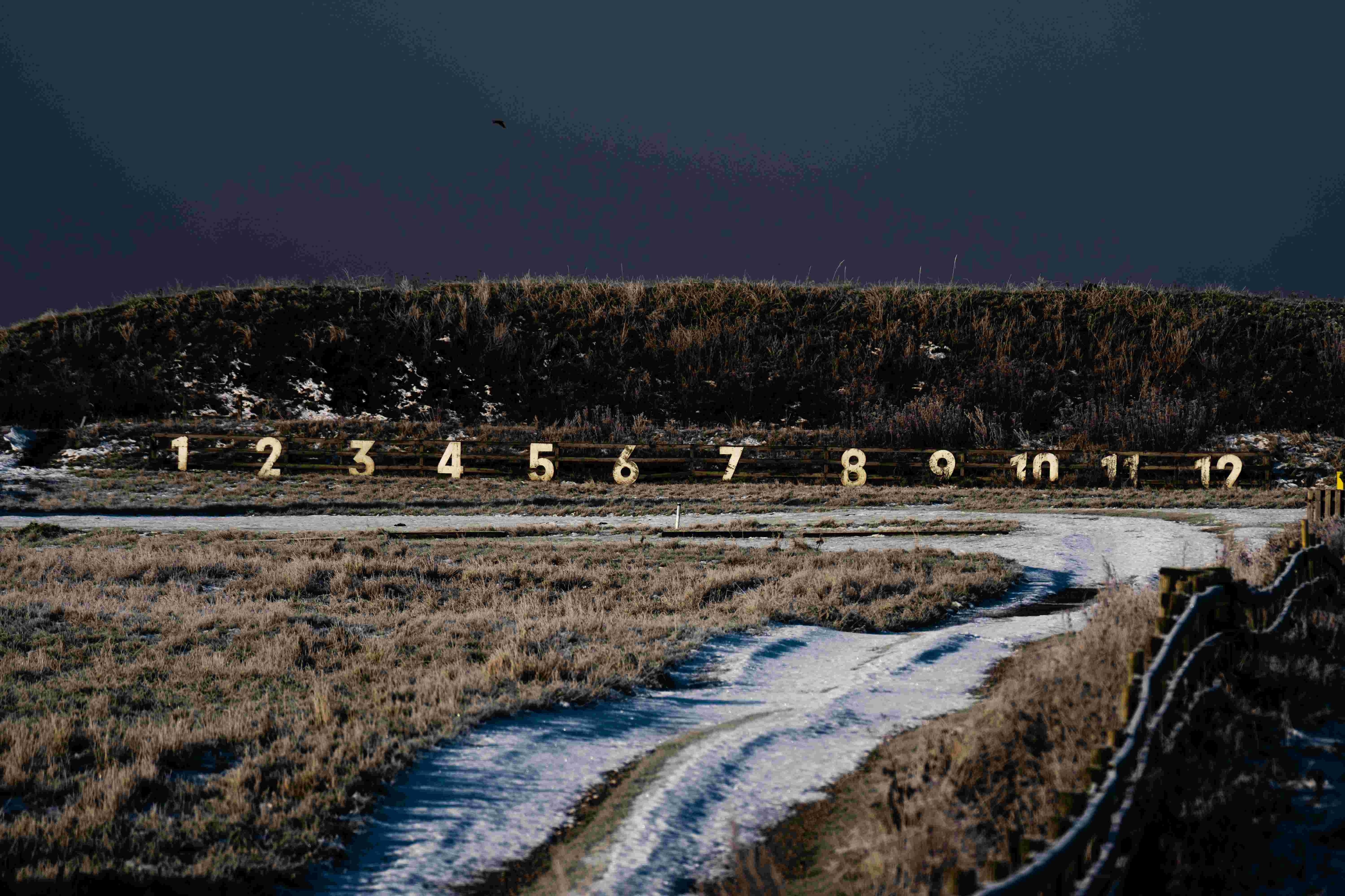 Shooting-range in a landscape with snow, under a dark winter sky.