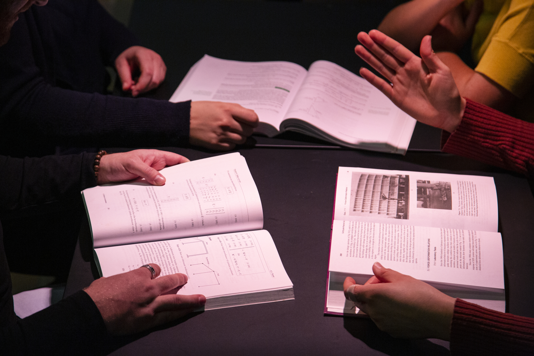 Hands over books. Four students seem to discuss in one of architect Anshelm´s houses at LTH.. Photo.