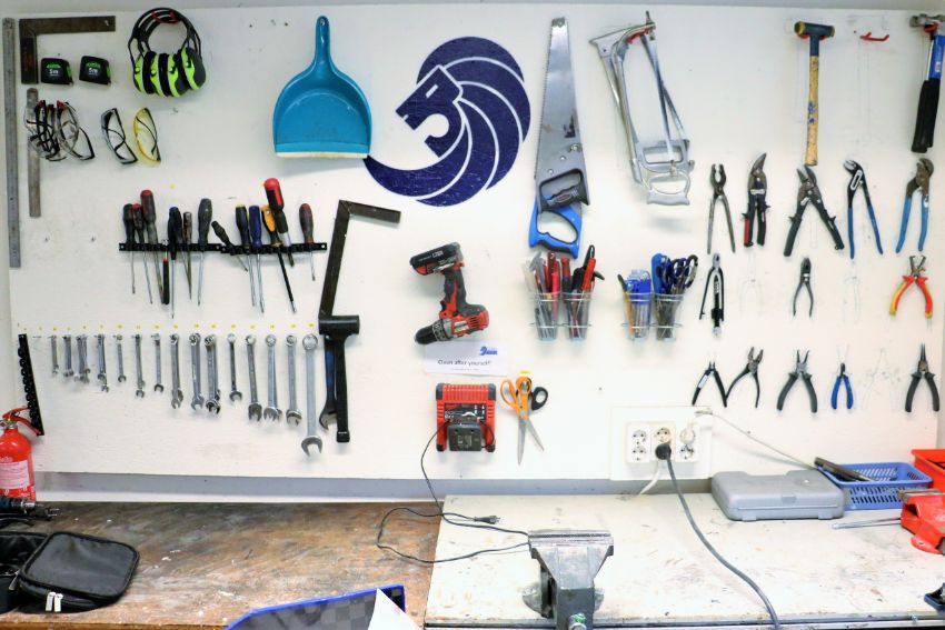 Wall in workshop where tools and logo of Lund Formula Student are visible.