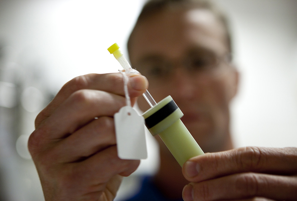 Mikeal Akke holds a test tube. Photo.