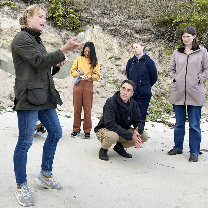 Caroline Hallin teaching students on a beach. Photo.