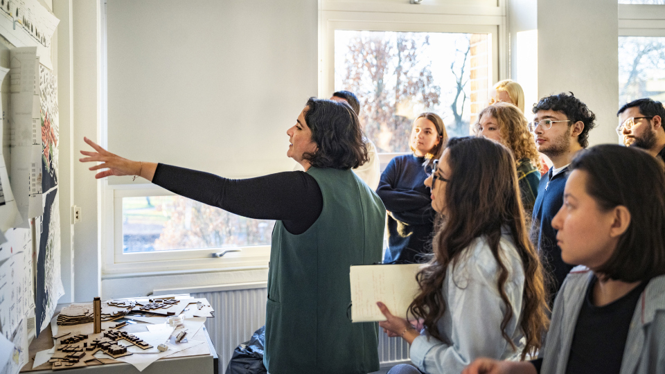 Studenter talar om en illustration som fästs på väggen.