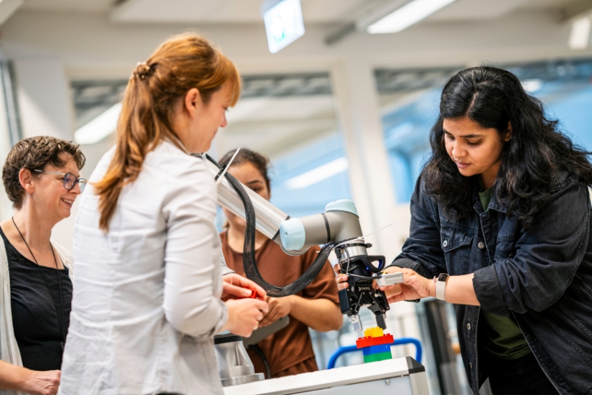Flera personer samarbetar runt en robot.