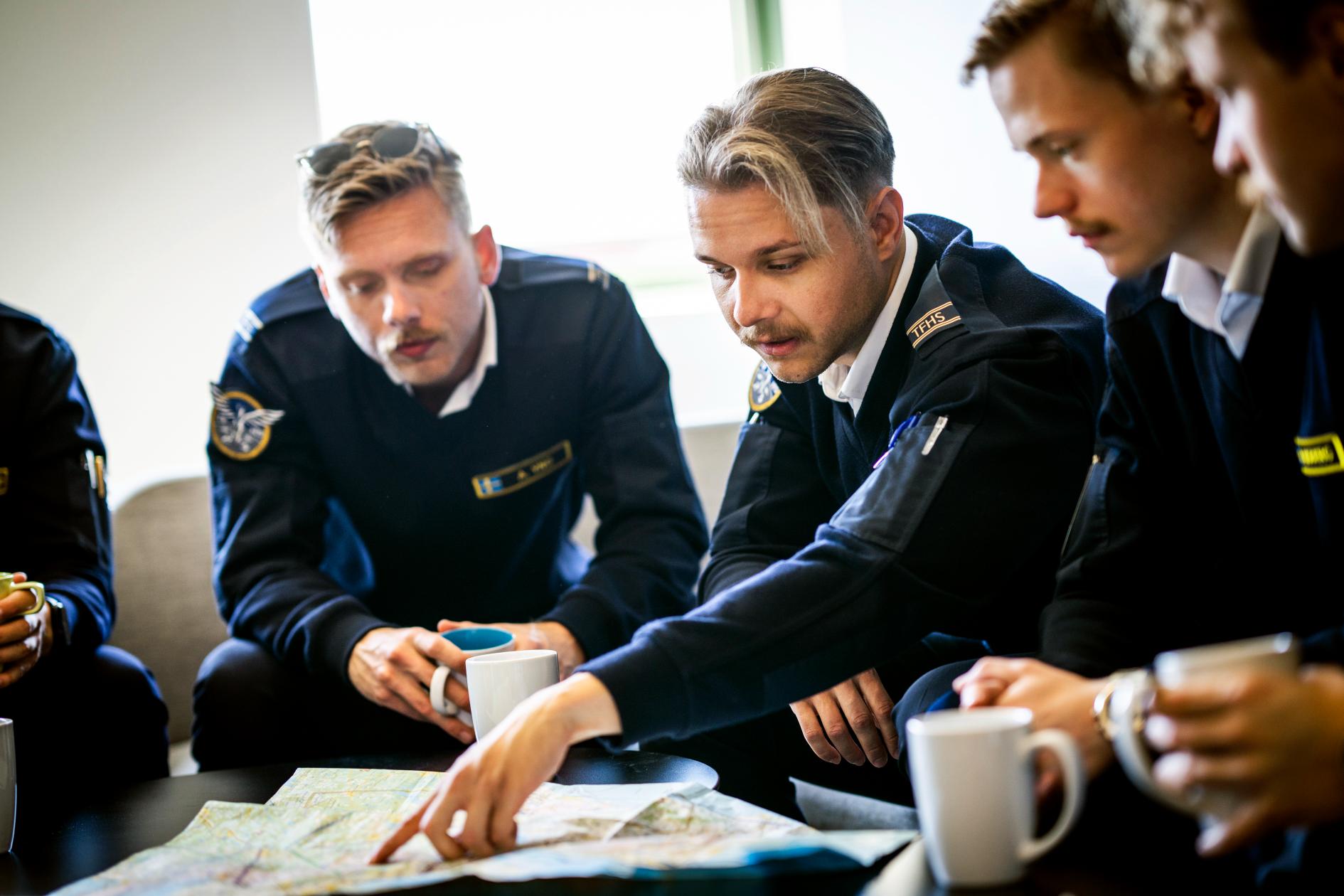 Pilotstudenter diskuterar en karta. Foto.